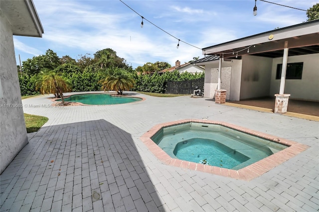 view of pool featuring a fenced in pool, a patio area, an in ground hot tub, and fence