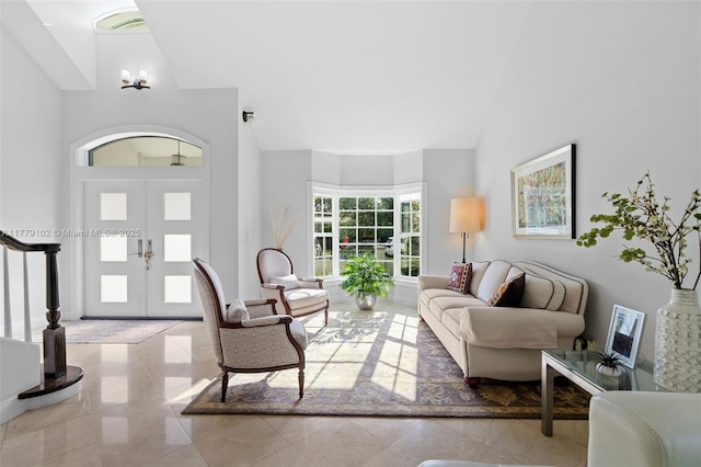 living area featuring high vaulted ceiling, stairs, and a chandelier