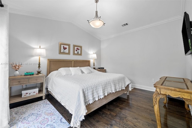 bedroom with wood finished floors, ornamental molding, vaulted ceiling, and visible vents