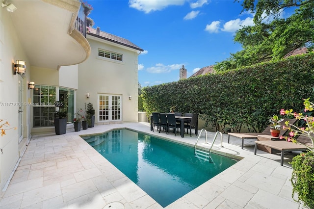 view of pool featuring a fenced in pool, a patio, french doors, and outdoor dining space