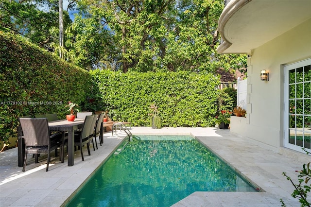 view of swimming pool featuring a patio area, a fenced in pool, and outdoor dining area