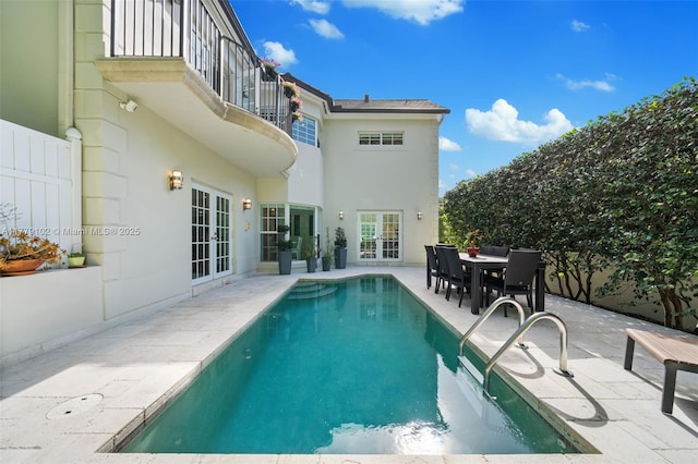 view of pool with a patio, french doors, a fenced in pool, and fence