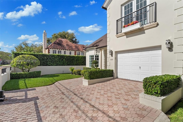 exterior space featuring decorative driveway and an attached garage