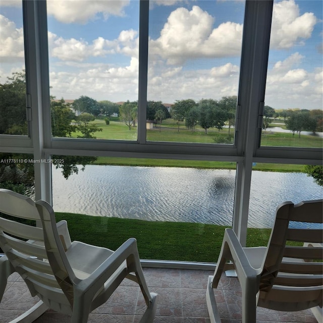 sunroom featuring a water view