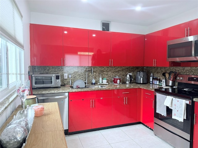 13255 SW 7th Ct Unit 401D, Pembroke Pines, FL 33027 - kitchen with red cabinetry, stainless steel appliances, a sink, tasteful backsplash, and light tile patterned floors