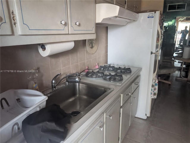 175 NE 203rd Ter Unit 24, Miami Gardens, FL 33179 - kitchen featuring tasteful backsplash, tile patterned flooring, under cabinet range hood, light countertops, and white gas cooktop