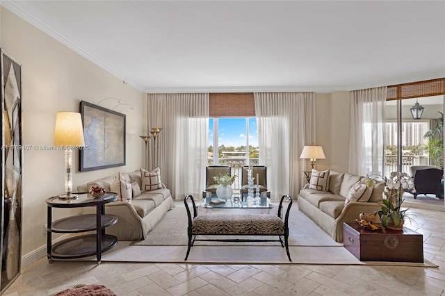 living room with crown molding, baseboards, and stone tile flooring