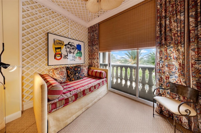 living area featuring carpet floors, ornamental molding, baseboards, and ceiling fan