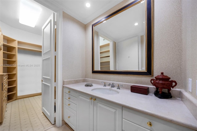 bathroom featuring vanity, recessed lighting, and a walk in closet