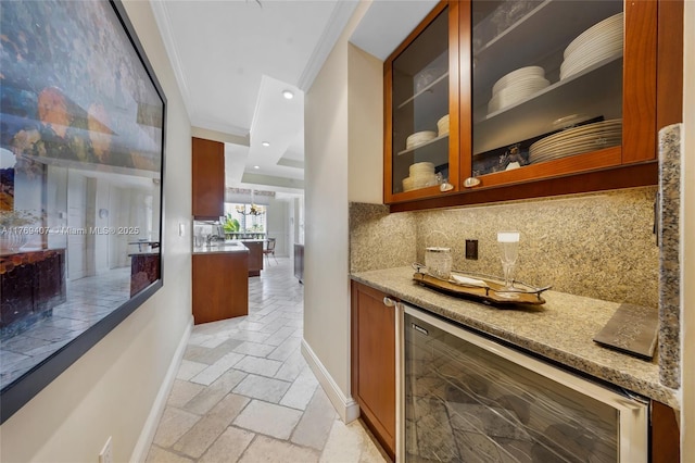 bar with backsplash, crown molding, baseboards, wine cooler, and stone tile floors