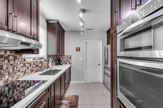 1500 SW 18th St, Miami, FL 33145 - kitchen featuring under cabinet range hood, a sink, dark brown cabinetry, stainless steel appliances, and tasteful backsplash