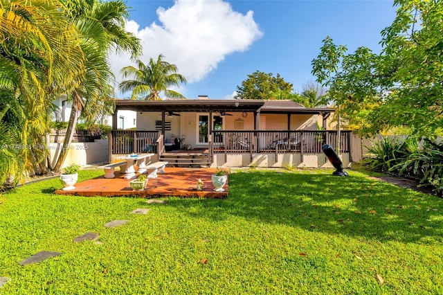 1500 SW 18th St, Miami, FL 33145 - rear view of property featuring a ceiling fan, a lawn, fence, stucco siding, and a deck
