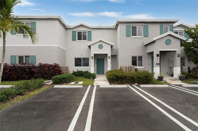 view of property featuring stucco siding and uncovered parking