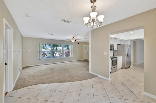 empty room featuring baseboards, light carpet, light tile patterned flooring, visible vents, and ceiling fan with notable chandelier