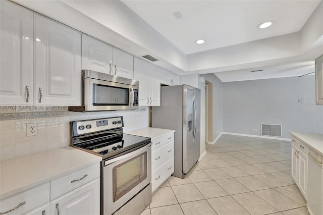kitchen with stainless steel appliances, tasteful backsplash, visible vents, and white cabinetry