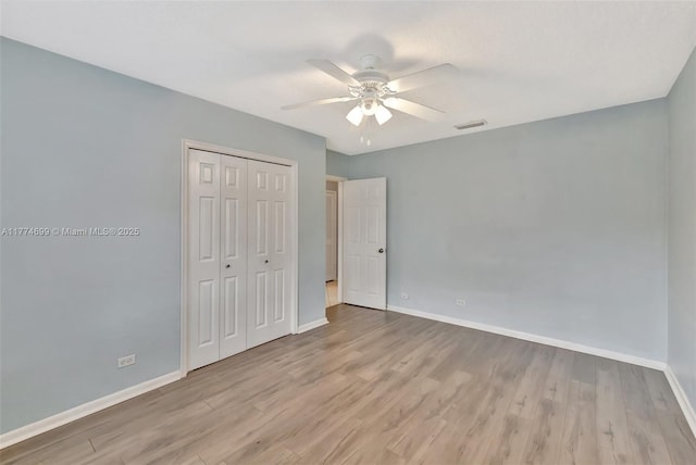 unfurnished bedroom featuring wood finished floors, baseboards, and visible vents