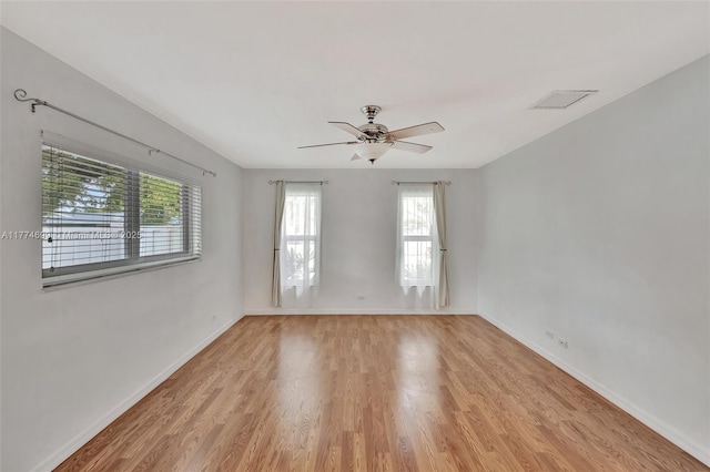 empty room featuring light wood finished floors, visible vents, baseboards, and ceiling fan