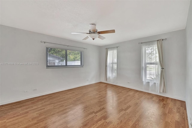 unfurnished room featuring baseboards, a ceiling fan, and wood finished floors