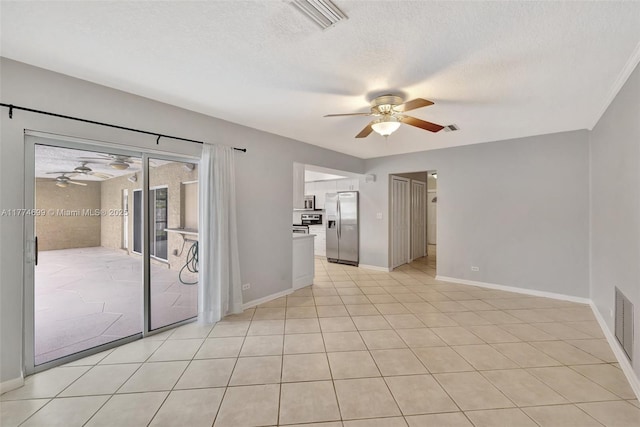 unfurnished room with visible vents, baseboards, a ceiling fan, and a textured ceiling