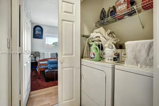 washroom featuring washer and clothes dryer, light wood-style floors, and laundry area