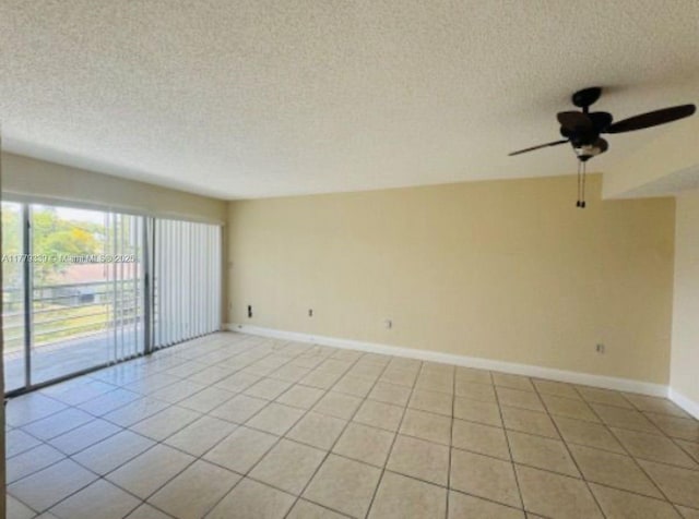 empty room featuring light tile patterned floors, baseboards, a ceiling fan, and a textured ceiling