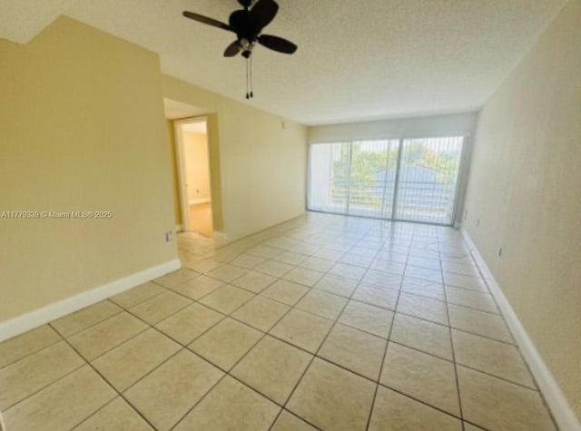 unfurnished room featuring light tile patterned floors, baseboards, and ceiling fan