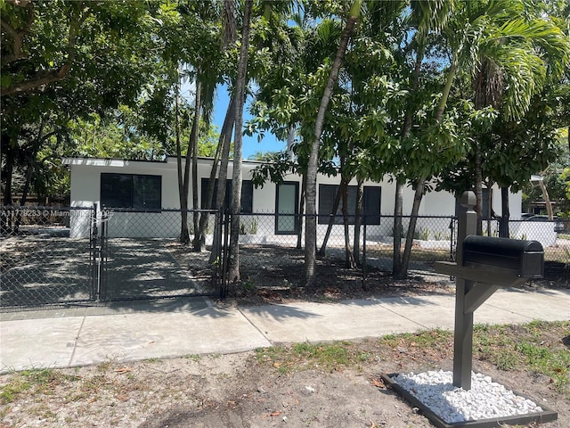 manufactured / mobile home with stucco siding, a gate, and a fenced front yard