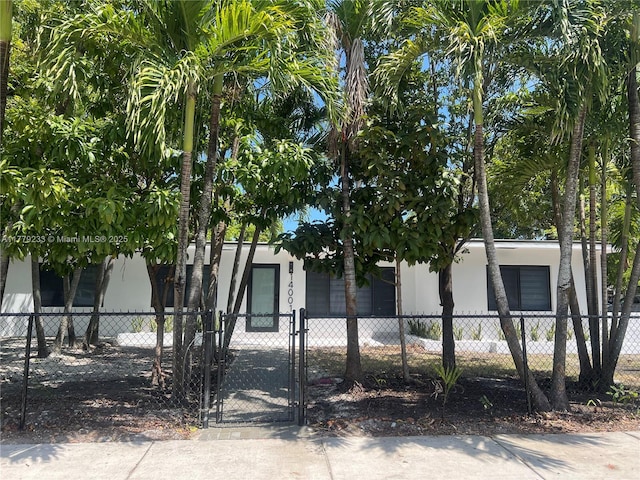 view of front of house featuring stucco siding, a gate, and a fenced front yard