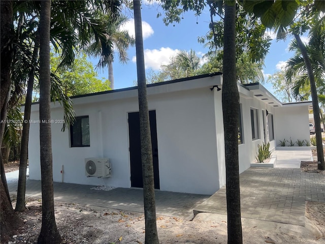 view of home's exterior featuring a patio, stucco siding, and ac unit