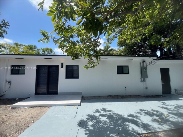 rear view of house featuring a patio and stucco siding