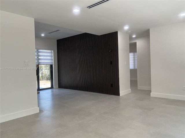 empty room featuring visible vents, baseboards, recessed lighting, and finished concrete flooring