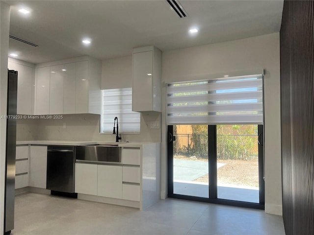 kitchen with visible vents, modern cabinets, a sink, light countertops, and white cabinetry