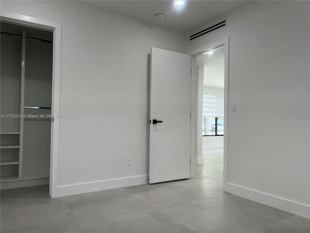 unfurnished bedroom featuring concrete floors, visible vents, and baseboards