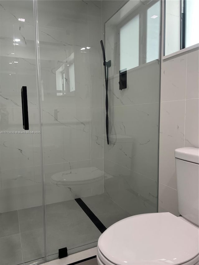 full bath featuring toilet and a marble finish shower