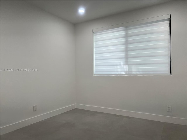 unfurnished room with baseboards