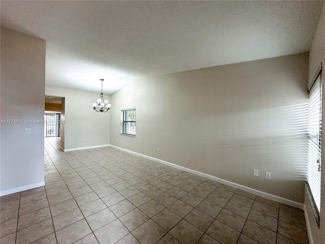 12459 SW 17th Ln, Miami, FL 33175 - spare room featuring a chandelier, light tile patterned floors, a textured ceiling, vaulted ceiling, and baseboards