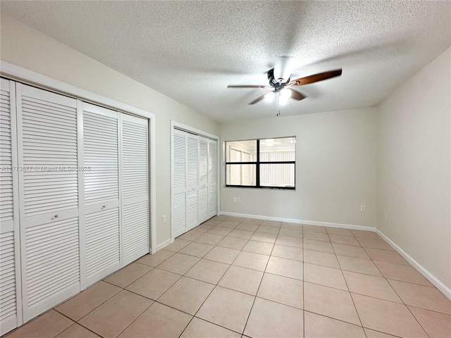 12459 SW 17th Ln, Miami, FL 33175 - unfurnished bedroom with multiple closets, light tile patterned floors, a textured ceiling, baseboards, and ceiling fan
