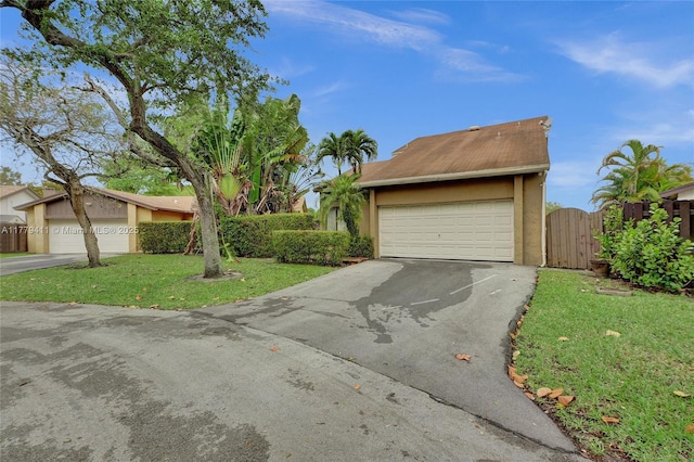 11724 SW 134th Ct, Miami, FL 33186 - view of front of home with aphalt driveway, stucco siding, a front lawn, and a gate