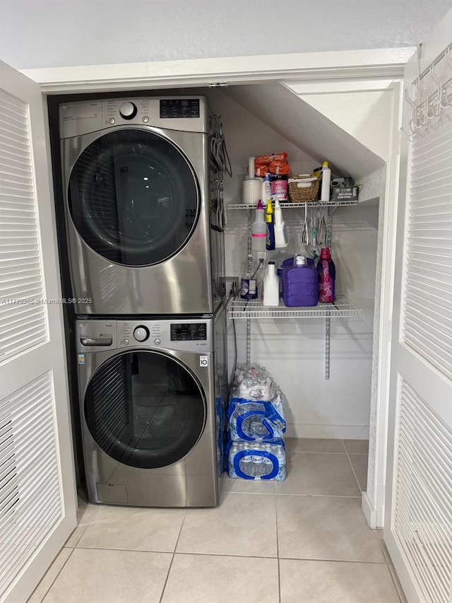 laundry room featuring tile patterned flooring, stacked washer / dryer, and laundry area