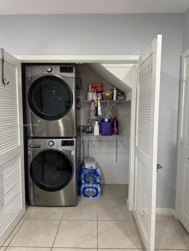 laundry room with tile patterned flooring, stacked washing maching and dryer, and laundry area