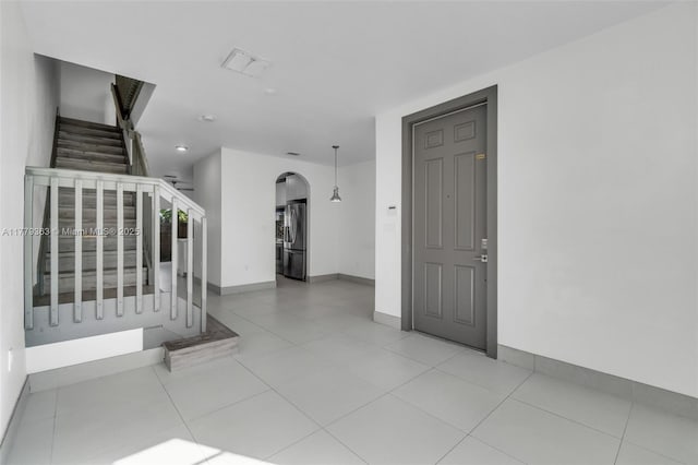 1720 NE 33rd Ave Unit 104-5, Homestead, FL 33033 - entrance foyer featuring stairs, arched walkways, baseboards, and tile patterned floors