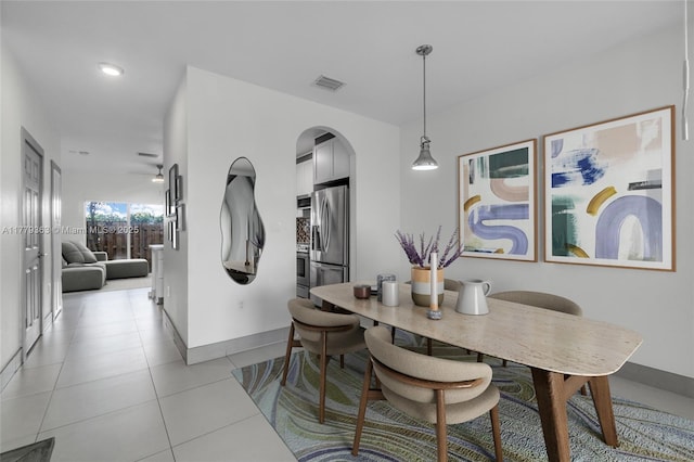1720 NE 33rd Ave Unit 104-5, Homestead, FL 33033 - dining space with baseboards, arched walkways, and light tile patterned floors
