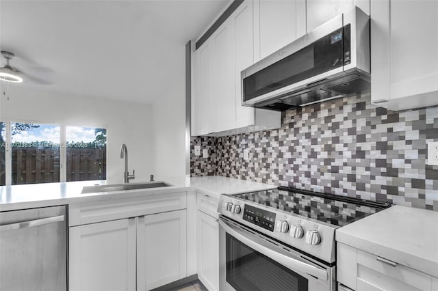 1720 NE 33rd Ave Unit 104-5, Homestead, FL 33033 - kitchen featuring appliances with stainless steel finishes, a sink, white cabinetry, and tasteful backsplash