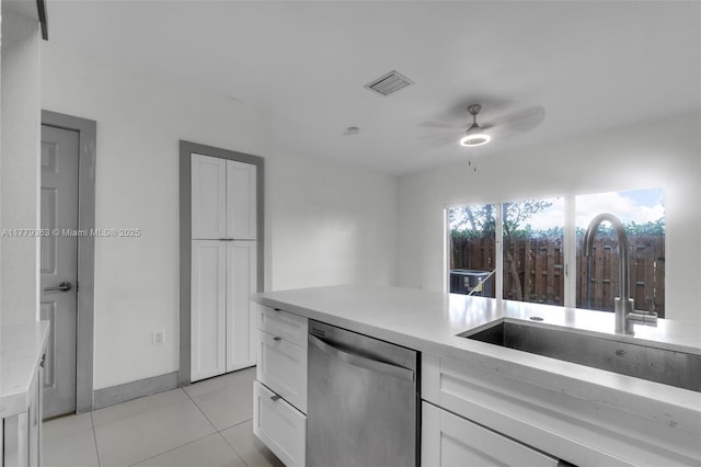 kitchen featuring white cabinetry, light tile patterned flooring, visible vents, dishwasher, and a sink