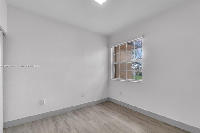unfurnished room with light wood-style flooring and baseboards