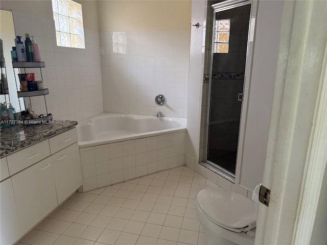 full bathroom featuring tiled bath, a stall shower, vanity, toilet, and tile patterned flooring