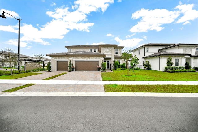 prairie-style home with an attached garage, stucco siding, decorative driveway, and a front lawn