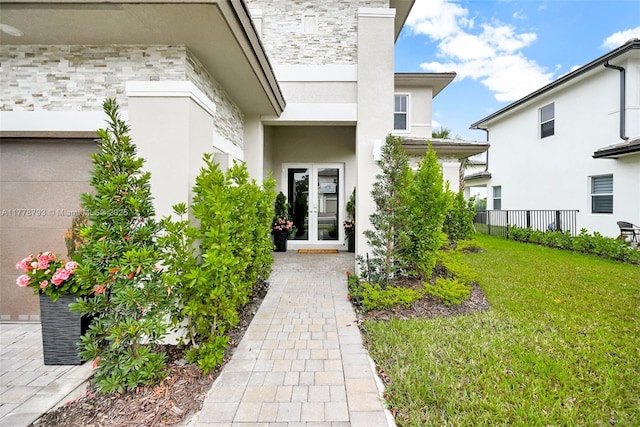 doorway to property featuring french doors, stucco siding, fence, and a yard