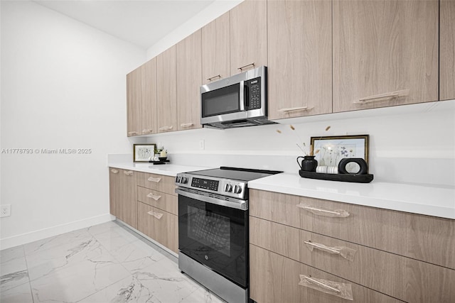 kitchen with light countertops, light brown cabinetry, and appliances with stainless steel finishes