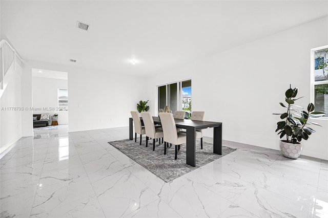dining area with plenty of natural light, visible vents, and marble finish floor